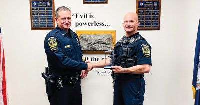 Jason Miller receives his Officer of the Year award from Chief of Police Mac Babb